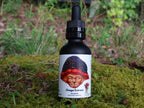 One black dropper bottle labeled Chaga from Mindfull Mycology, displayed on green moss with a forest background.
