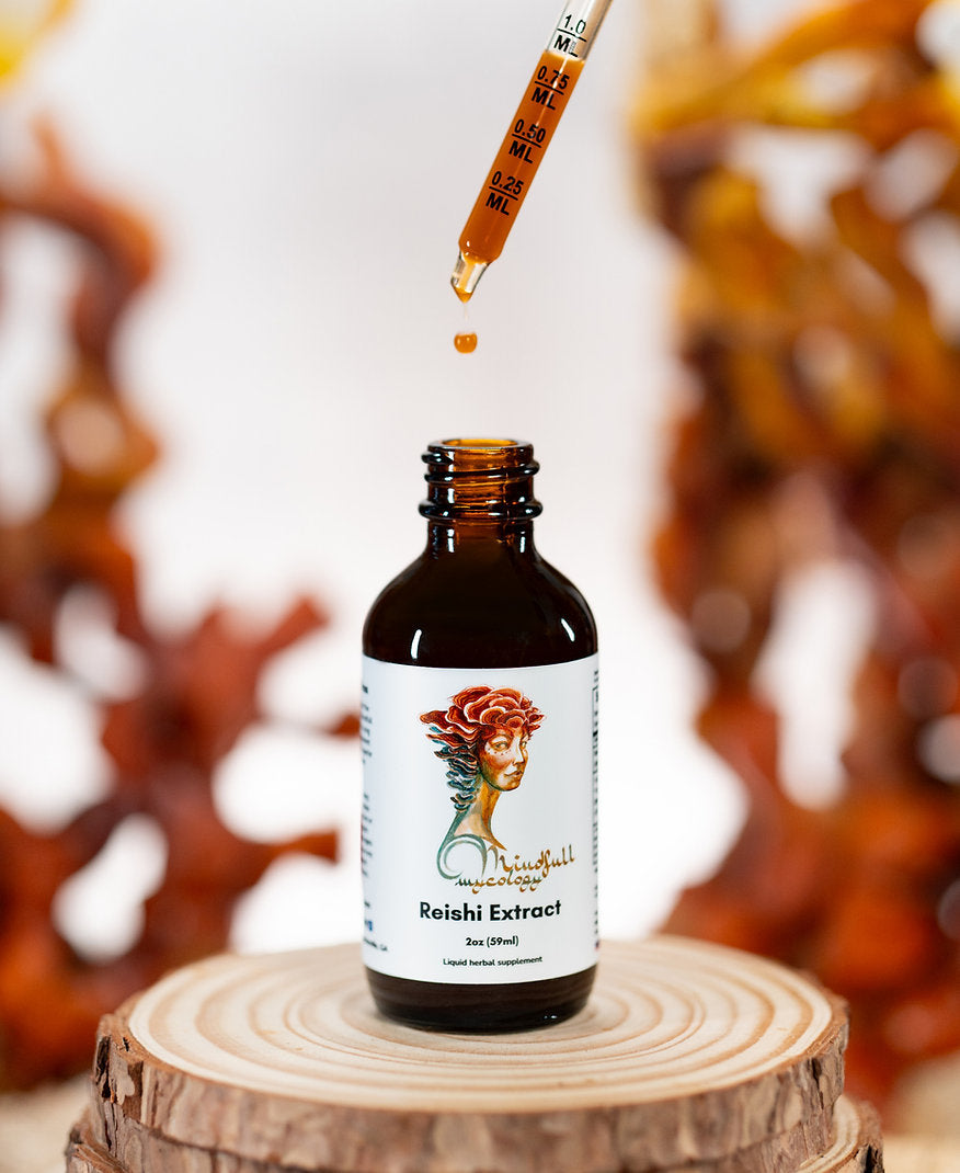 Bottle of Reishi Extract from Mindfull Mycology with a dropper on a wooden surface